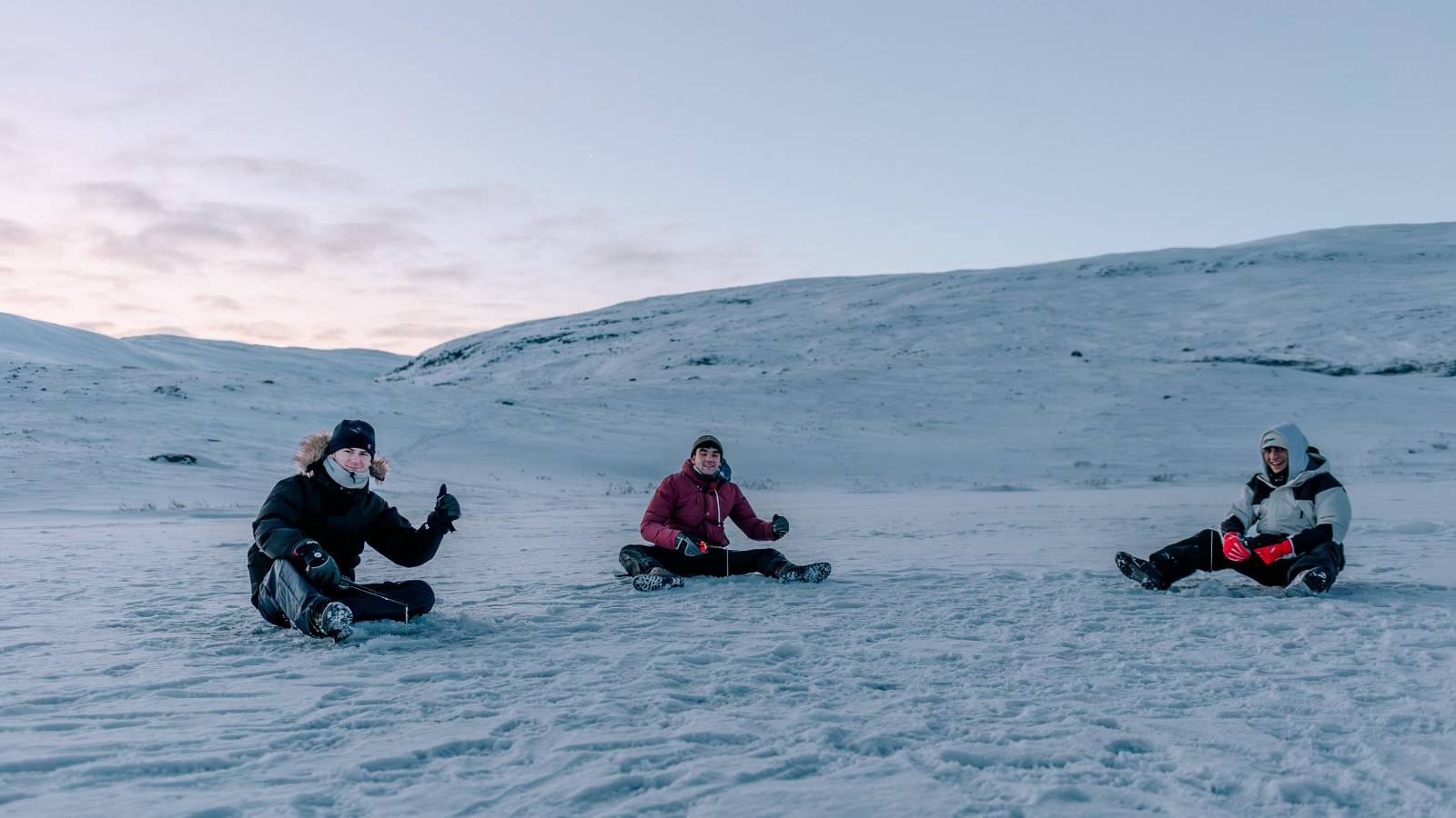 Ice fishing on frozen lake in Swedish Lapland.